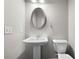 Neat half bath with a pedestal sink, oval mirror, and a standard white toilet at 72 Summer Nw Pl, Cartersville, GA 30121