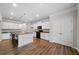 Bright kitchen with white cabinets, a dark island, stainless appliances, and wood-look flooring at 72 Summer Nw Pl, Cartersville, GA 30121