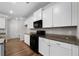 Kitchen features white cabinets, dark granite countertops and black appliances at 72 Summer Nw Pl, Cartersville, GA 30121