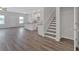 Open-concept living space with hardwood floors, white walls, stairs, and a view into the kitchen at 8664 Webb Rd, Riverdale, GA 30274