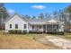 White ranch style home's backyard featuring a deck, covered porch and lush landscaping at 9369 Kraft Dr, Winston, GA 30187