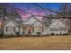 Charming single Gathering home with red front door and white painted wood facade and dark shutters at 9369 Kraft Dr, Winston, GA 30187