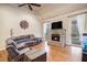 Living room features a cozy stone fireplace, hardwood floors, ceiling fan, and a large sectional sofa at 9369 Kraft Dr, Winston, GA 30187