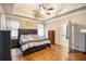 Main bedroom with tray ceiling, ceiling fan, and a door leading into the ensuite bathroom at 9369 Kraft Dr, Winston, GA 30187