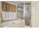 Large soaking tub and glass enclosed shower in neutral colored bathroom at 1059 Hedge Rose Ne Ct, Atlanta, GA 30324