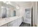 Bright bathroom features a double sink vanity, large mirror, and gray tile flooring at 1059 Hedge Rose Ne Ct, Atlanta, GA 30324