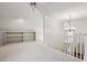 Upstairs loft with chandelier, white carpet, and banister at 1059 Hedge Rose Ne Ct, Atlanta, GA 30324