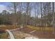 Aerial view of backyard featuring a shed, wooden fence, a walkway, and trees. Bare trees create a wooded feel at 1554 Sage Ridge Dr, Marietta, GA 30064