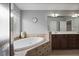 Bright bathroom featuring a tub with tile surround and a dark wood vanity with dual sinks at 1554 Sage Ridge Dr, Marietta, GA 30064