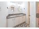 Bright bathroom featuring double sinks with a modern gray countertop and unique hexagon patterned floor tiles at 2426 Vivian Cir, Decatur, GA 30030