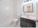 Well-lit bathroom featuring a vanity with a dark cabinet base, a large mirror, and a tub with a shower at 2426 Vivian Cir, Decatur, GA 30030