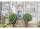 Home's entryway featuring a stone staircase, iron railing, a blue front door, and manicured bushes at 2426 Vivian Cir, Decatur, GA 30030