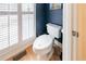 A small powder room with a hardwood floor, and a classic white toilet next to window shutters at 2426 Vivian Cir, Decatur, GA 30030