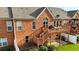 Rear exterior view showing the brick facade and wooden deck with stairs leading to a patio at 352 Lauren Ln, Woodstock, GA 30188