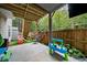 Back patio with playset, sand table, and view of the fenced backyard and wooded area at 3865 Brookhollow Dr, Douglasville, GA 30135