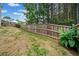 Expansive backyard is partially fenced and features a mix of green grass and vegetation at 3865 Brookhollow Dr, Douglasville, GA 30135