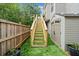 Artificial turf stairs lead to the upper yard, along a wood fence and a storage building at 3865 Brookhollow Dr, Douglasville, GA 30135