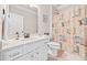 Well-lit bathroom features a vanity with storage, a toilet, and a shower with a patterned curtain at 3865 Brookhollow Dr, Douglasville, GA 30135