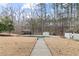 Backyard view of the in-ground pool with a diving board, surrounded by lush landscaping at 398 Picketts Xing, Acworth, GA 30101