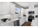 Well-lit kitchen features white cabinetry, stainless steel appliances, ample counter space, and stylish backsplash at 147 Park Lane Ln, Fairburn, GA 30213