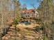 Expansive aerial view of a luxurious home with a pool, lush landscaping, gazebo and an outdoor area surrounded by trees at 3460 Mansions Pkwy, Berkeley Lake, GA 30096