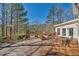 Wooden back deck features patio furniture and overlooks a lush wooded backyard at 3460 Mansions Pkwy, Berkeley Lake, GA 30096