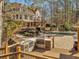 A backyard showcasing an outdoor kitchen, dining patio, and a pool at 3460 Mansions Pkwy, Berkeley Lake, GA 30096