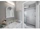 Stylish bathroom featuring marble countertop, decorative mirror, and glass-enclosed shower at 3460 Mansions Pkwy, Berkeley Lake, GA 30096