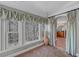 Bright bedroom sitting area with large windows, custom drapes, and an arched doorway leading to the luxurious bathroom at 3460 Mansions Pkwy, Berkeley Lake, GA 30096