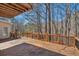 Large wooden deck with railing offers serene outdoor living space surrounded by trees, great for relaxation and entertaining at 3460 Mansions Pkwy, Berkeley Lake, GA 30096