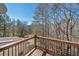 Wooden deck with iron railings overlooking a lush, wooded backyard at 3460 Mansions Pkwy, Berkeley Lake, GA 30096