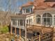 Back exterior with ample windows and a wooden deck with steps down to the yard at 3460 Mansions Pkwy, Berkeley Lake, GA 30096