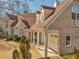 Elegant brick home showcasing architectural details, covered entrance, and well-manicured landscaping at 3460 Mansions Pkwy, Berkeley Lake, GA 30096