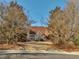 A stately brick home has a circular driveway lined with mature trees and manicured landscaping at 3460 Mansions Pkwy, Berkeley Lake, GA 30096