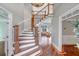 Elegant foyer with hardwood floors, a curved staircase, and views of the living room at 3460 Mansions Pkwy, Berkeley Lake, GA 30096