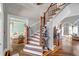 Elegant foyer with hardwood floors, a curved staircase, and views of the living room at 3460 Mansions Pkwy, Berkeley Lake, GA 30096