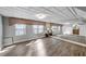 Bright living room featuring hardwood floors, large mirror wall, and access to a bathroom at 3460 Mansions Pkwy, Berkeley Lake, GA 30096