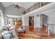 Spacious living room features hardwood floors, a fireplace, and abundant natural light from large windows at 3460 Mansions Pkwy, Berkeley Lake, GA 30096