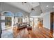 Open-concept living room with hardwood floors, vaulted ceiling, expansive windows, and access to the kitchen and dining areas at 3460 Mansions Pkwy, Berkeley Lake, GA 30096