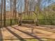 Hand-crafted wooden bench surrounded by decorative black iron fence in a serene wooded outdoor area at 3460 Mansions Pkwy, Berkeley Lake, GA 30096