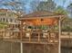 Charming gazebo with an outdoor kitchen including a grill, dining area, and wooded views of the home's exterior at 3460 Mansions Pkwy, Berkeley Lake, GA 30096