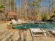 A backyard swimming pool and lounge chairs, surrounded by a brick patio and trees at 3460 Mansions Pkwy, Berkeley Lake, GA 30096