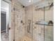 Modern tiled shower features glass doors, a rain shower head, and built-in shelving at 3460 Mansions Pkwy, Berkeley Lake, GA 30096