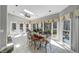 Bright sunroom with tile floors, dining table, and views of the wooded backyard at 3460 Mansions Pkwy, Berkeley Lake, GA 30096