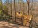 Elevated tree house accessed by a wooden bridge and secured by a decorative fence in a wooded setting at 3460 Mansions Pkwy, Berkeley Lake, GA 30096