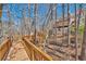 A wooden walkway weaves through a wooded lot, leading to a large house with a deck at 3460 Mansions Pkwy, Berkeley Lake, GA 30096