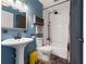 Stylish blue bathroom featuring a pedestal sink, a shower-tub combo, and modern fixtures at 633 Mckoy St, Decatur, GA 30030