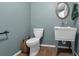 Half bath with single vanity and a toilet. Freshly painted in neutral blue at 6890 Cedar Mountain Rd, Douglasville, GA 30134