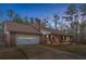 Charming brick home with an attached garage, a front porch, and manicured landscaping under a colorful sky at 6890 Cedar Mountain Rd, Douglasville, GA 30134