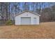 Detached garage with roll-up door and separate entrance, surrounded by trees and lawn at 6890 Cedar Mountain Rd, Douglasville, GA 30134